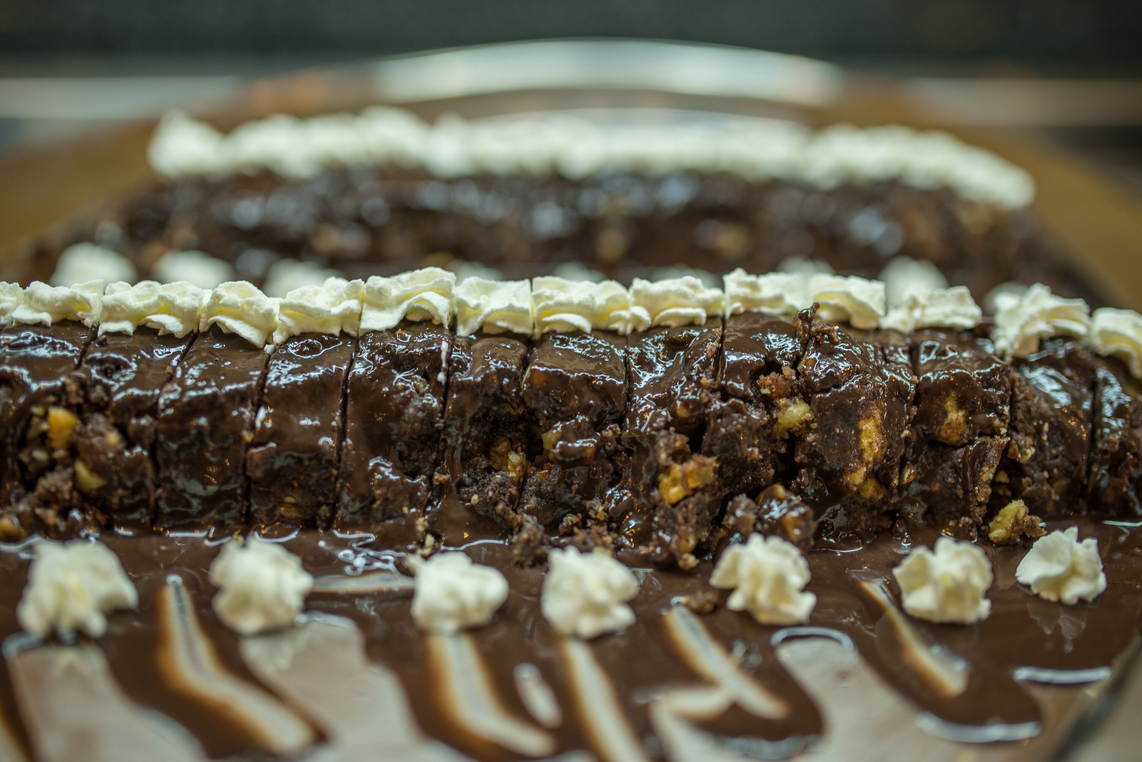 A chocolate dessert with whipped cream and chocolate sauce.