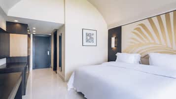 Ein modernes Hotelzimmer mit einem großen Bett, einem Schreibtisch und einem gerahmten Kunstwerk an der Wand.