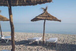Playa privada, sillas reclinables de playa, sombrillas, bar en la playa