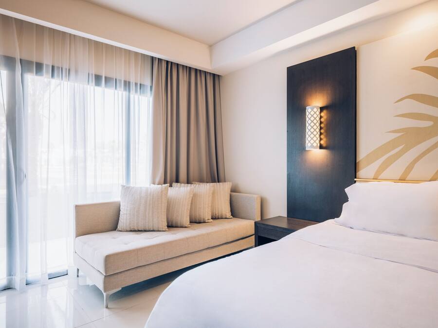 Een moderne hotelkamer met een groot bed, een bank en een wandlamp.