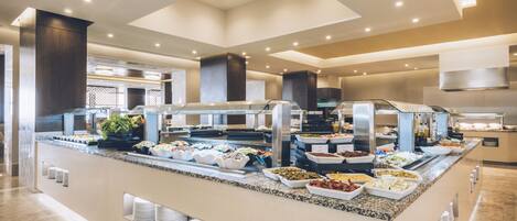 A buffet with various food options and a modern interior design.