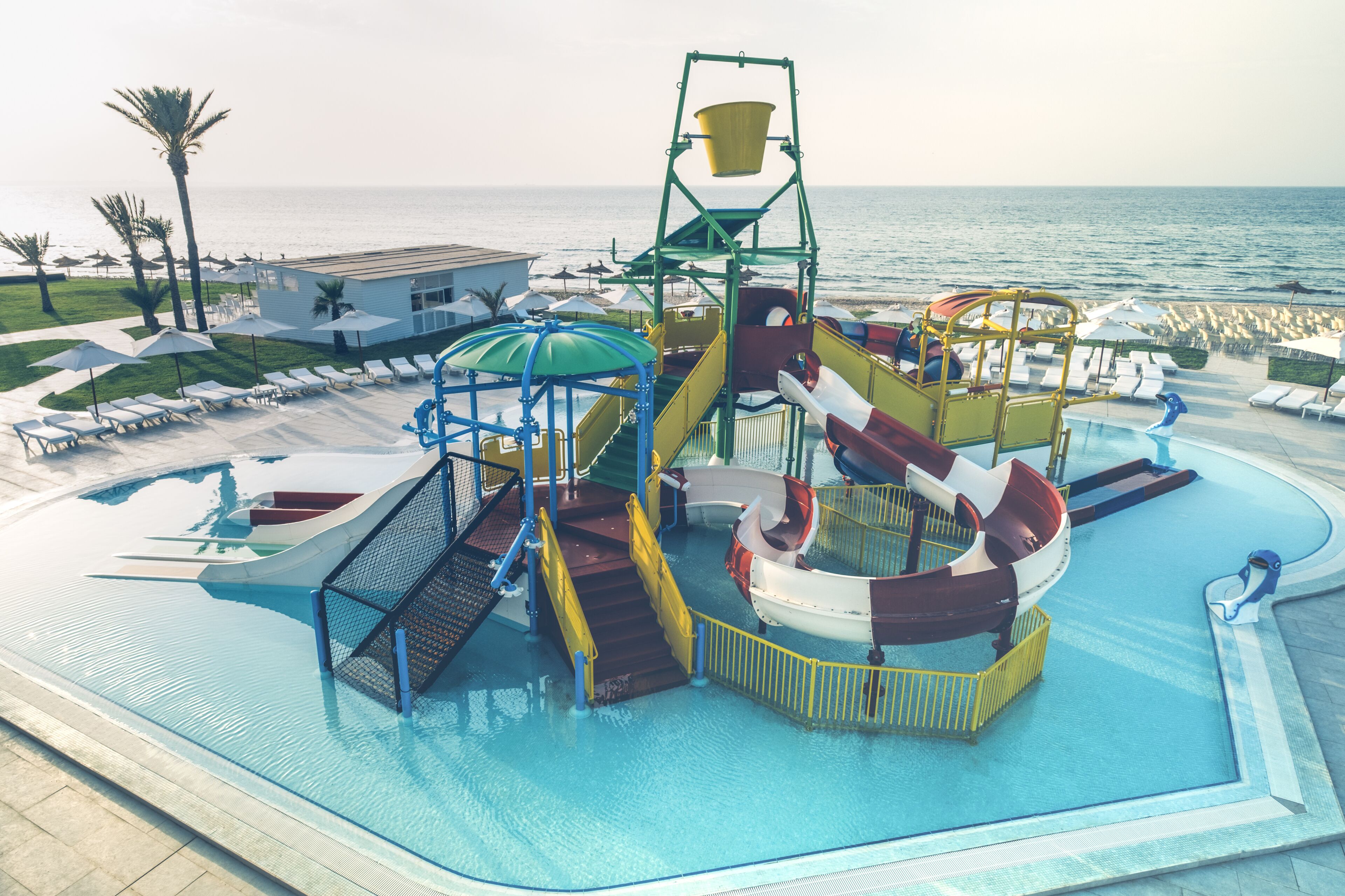 A water park with a large pool, slides, and a wave machine.