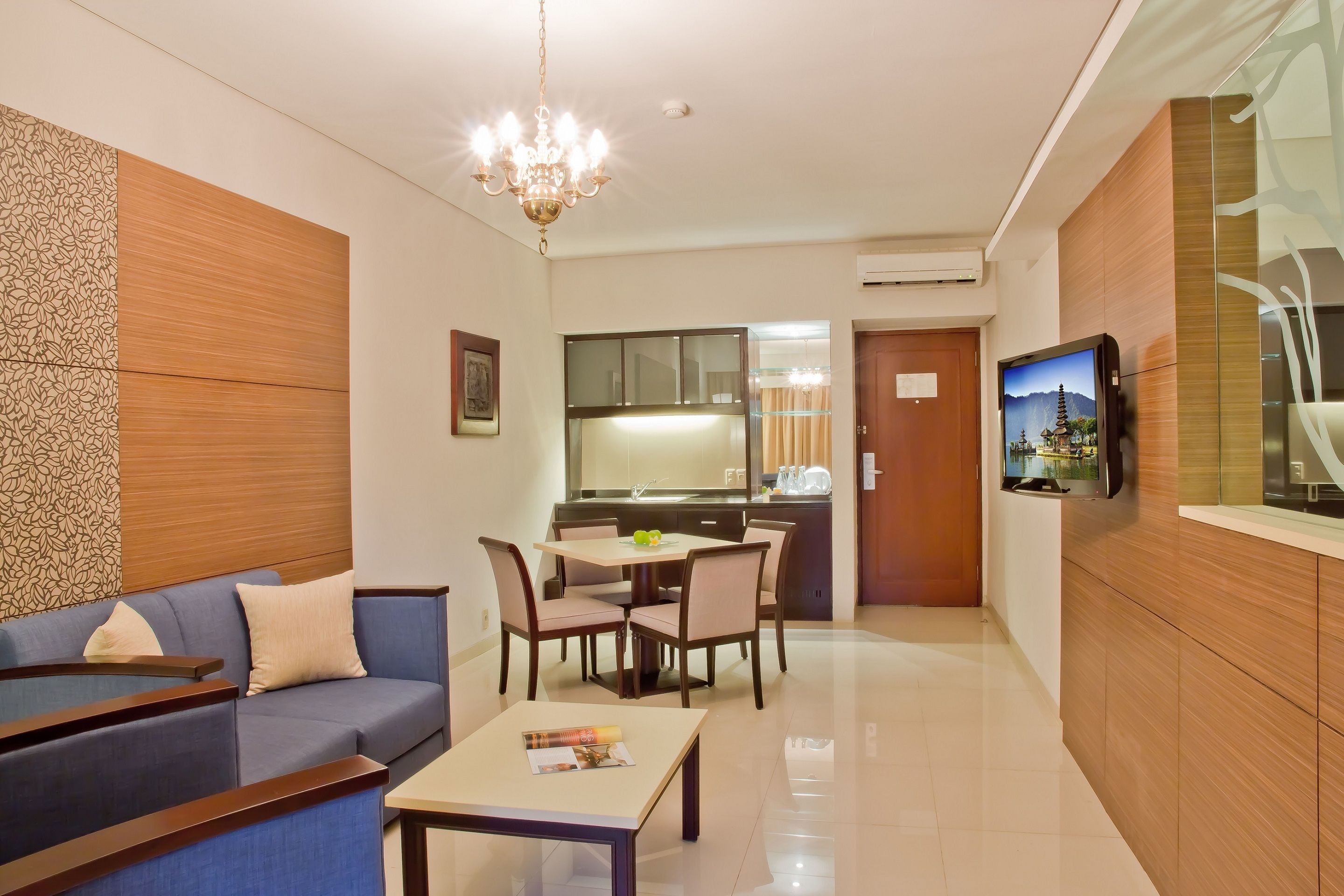 A modern living room with a sofa, a dining table, and a TV.