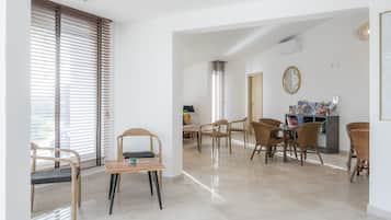 Relax in this stylish living area with a dining table, comfortable seating, and a large window.