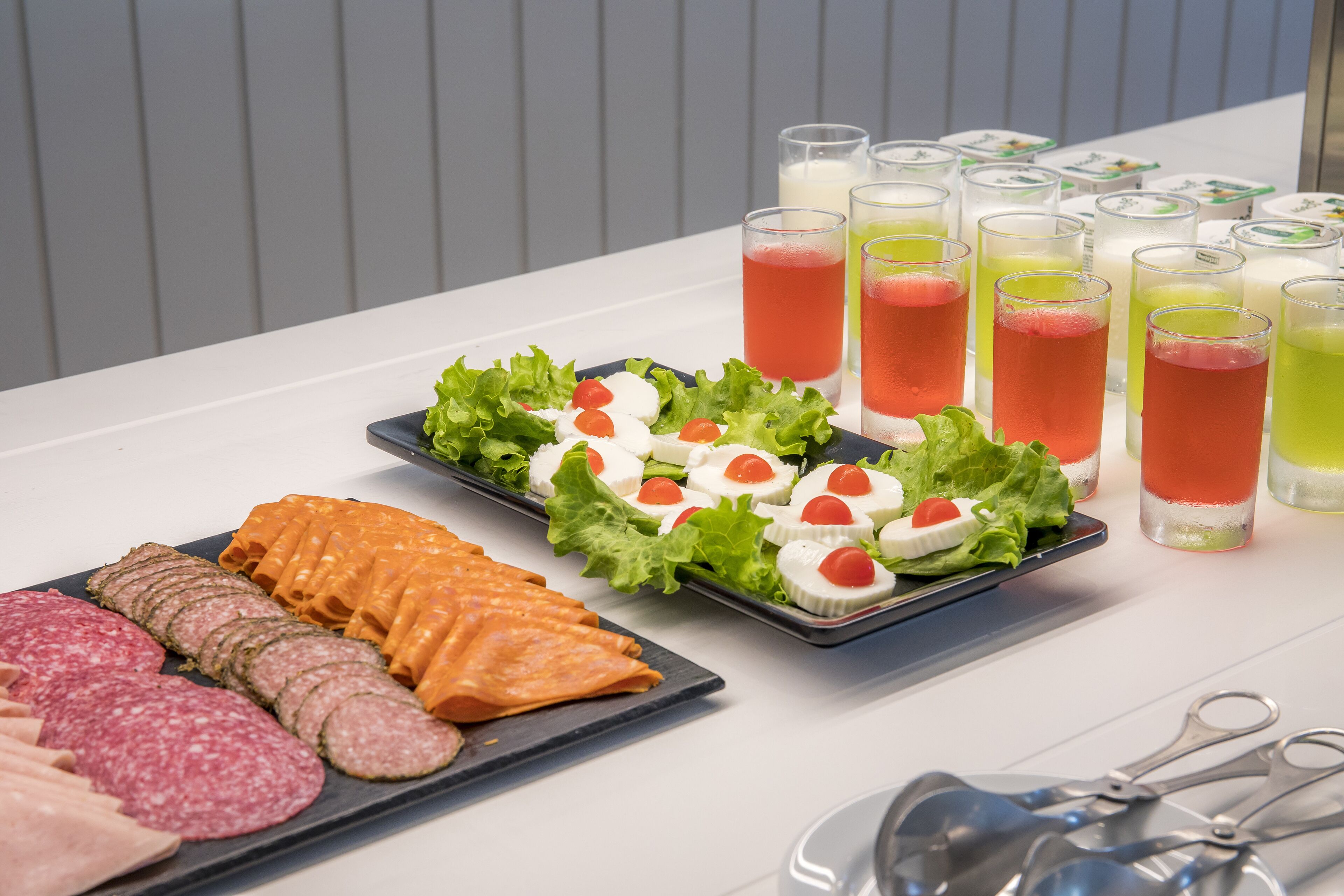 A buffet table with various food items and drinks.