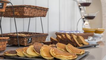 Un buffet de petit-déjeuner proposant un assortiment de viennoiseries et de crêpes.