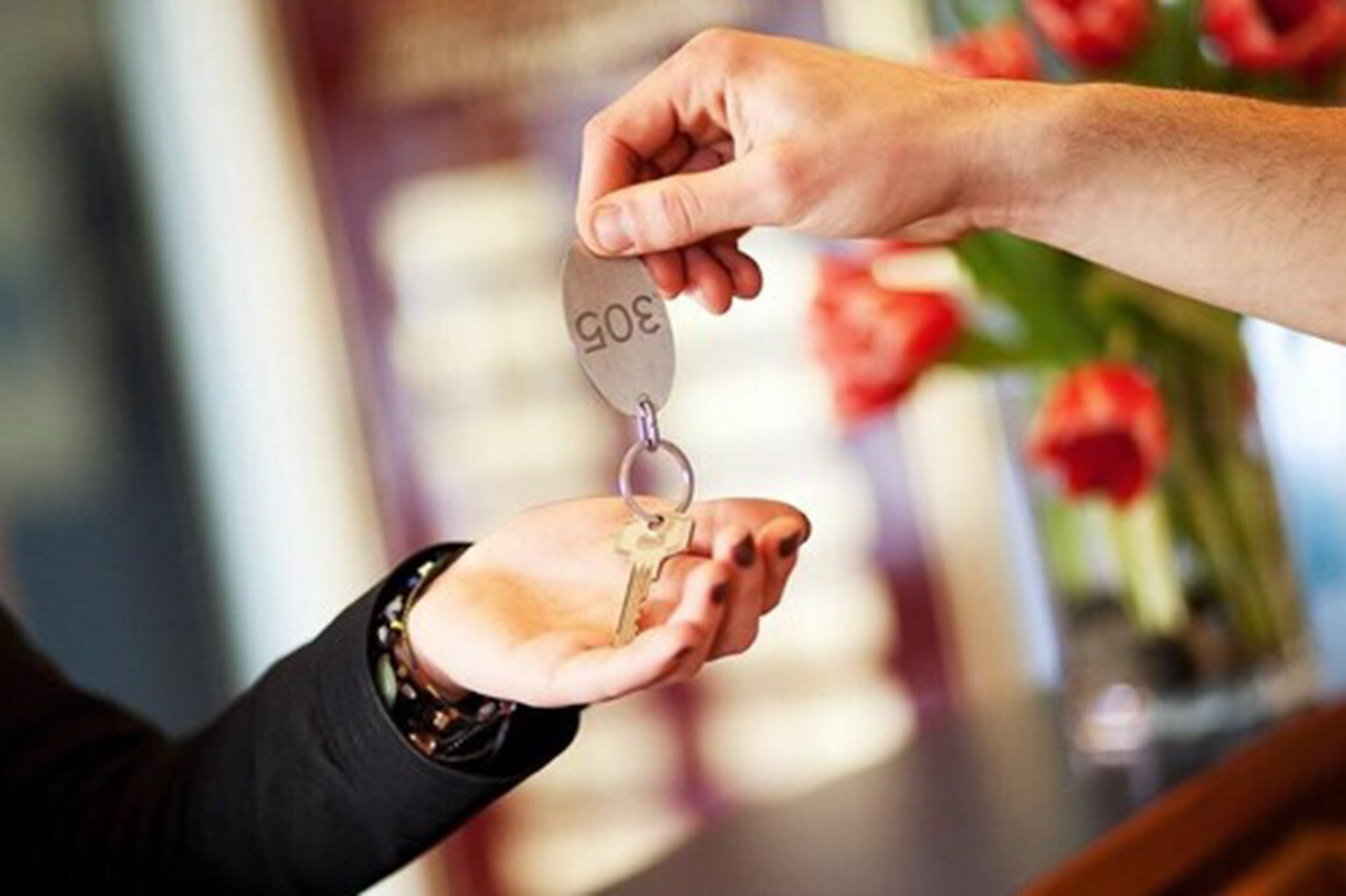 A hand holding a key with a metal tag.
