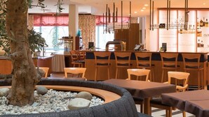 Un restaurant doté d’un foyer central, de plusieurs espaces de détente et d’un bar proposant un large choix de bouteilles et de verres.