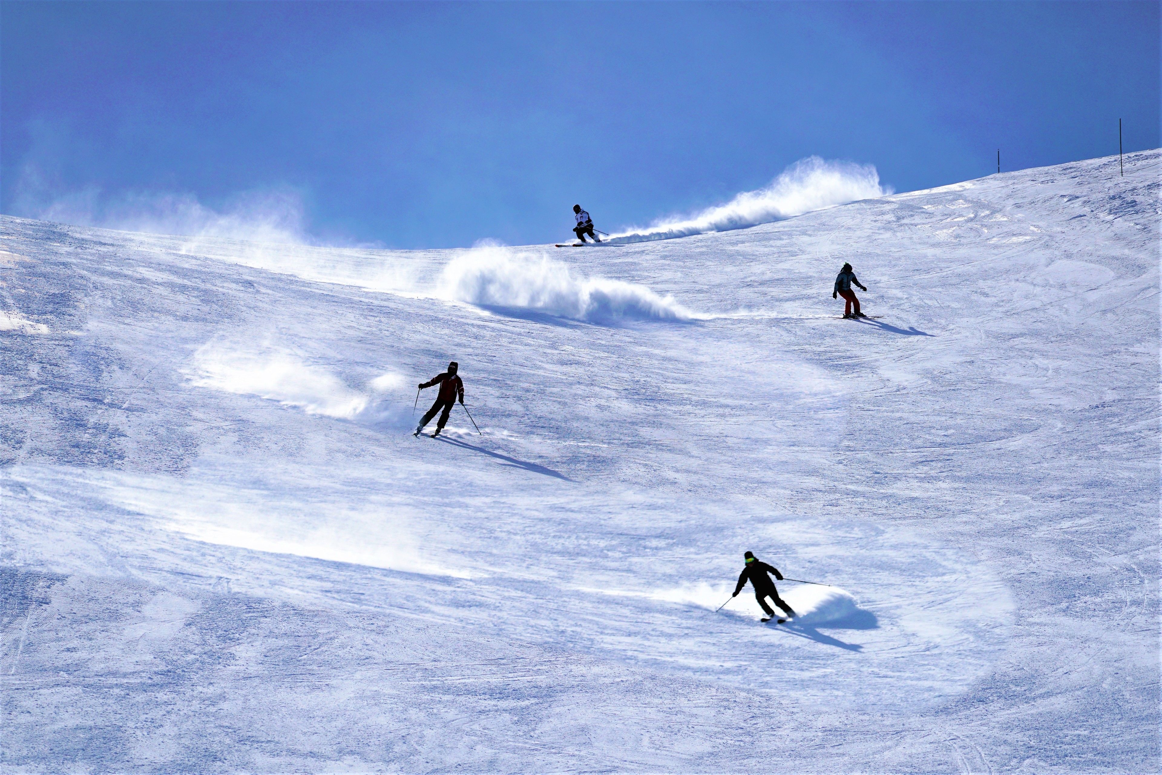 A snowy slope with skiers.