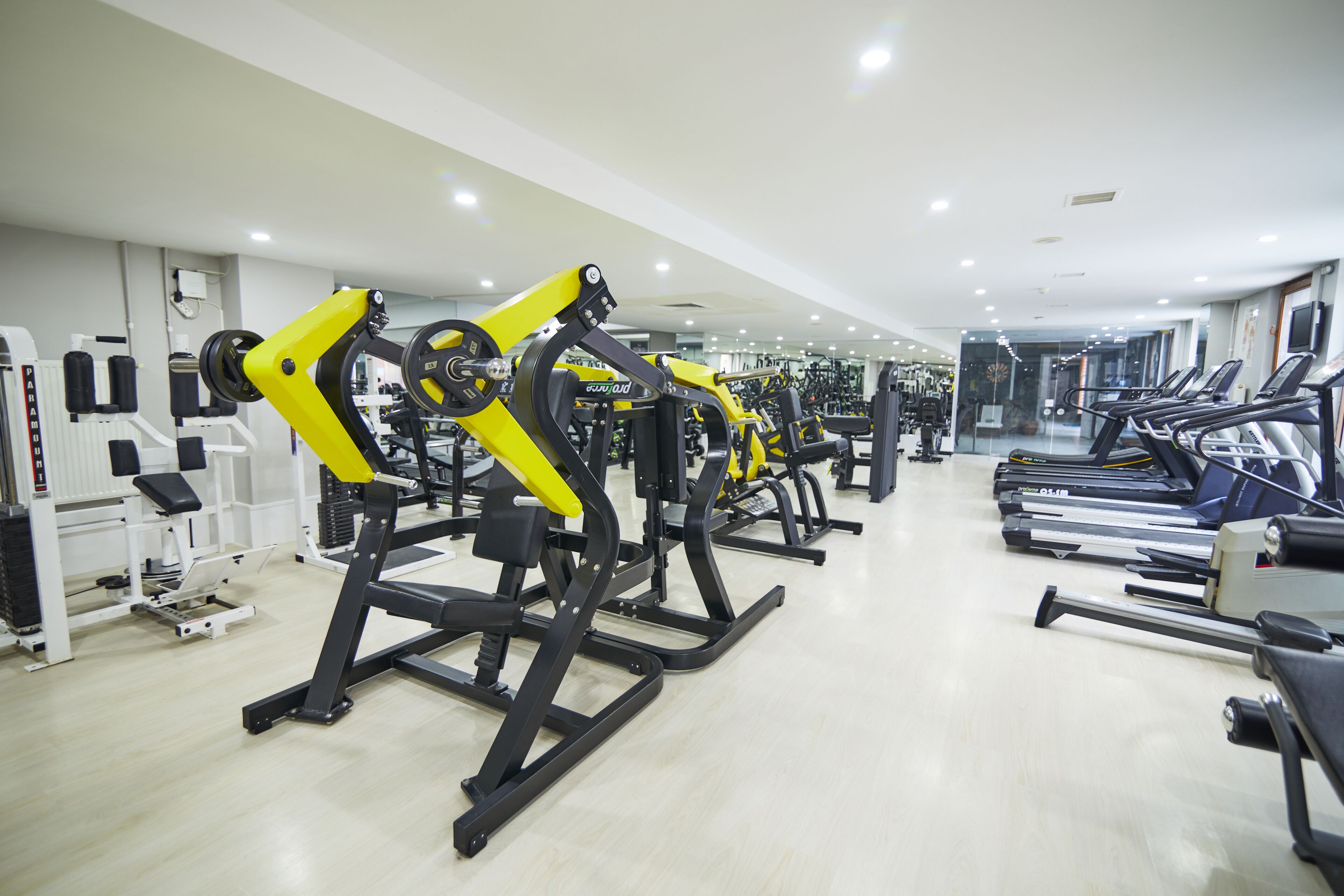 A gym with various exercise machines, including treadmills and weightlifting equipment.