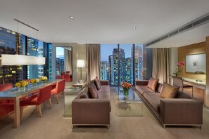 Une chambre d’hôtel moderne avec vue sur la ville, un coin repas et un espace salon.