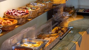 A buffet with various food items including eggs, sausages, and bread. - Maltezos (Corfu)