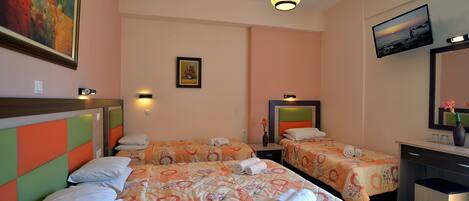 A hotel room with two beds, a desk, a chair, a TV, and a painting on the wall.