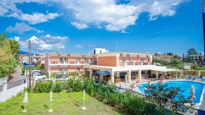 A hotel with a swimming pool, outdoor seating, and a covered area. - Maltezos (Corfu)