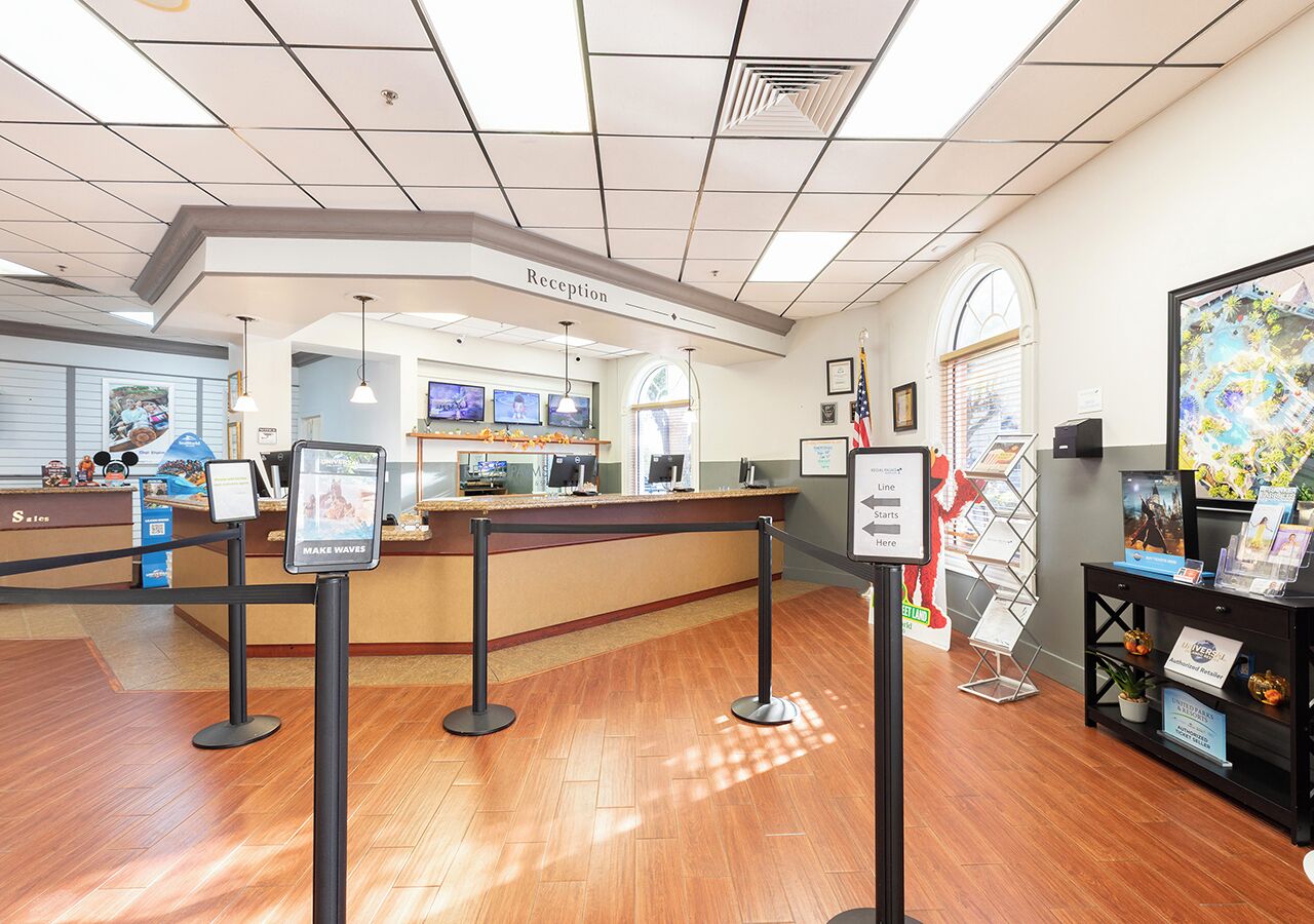 Un área de recepción con mostrador, zona de espera y una exhibición de libros y revistas.