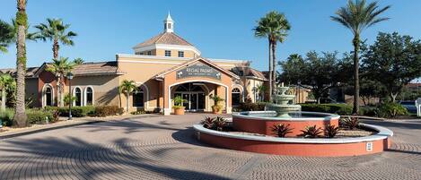 A hotel with a central fountain, palm trees, and a paved courtyard.