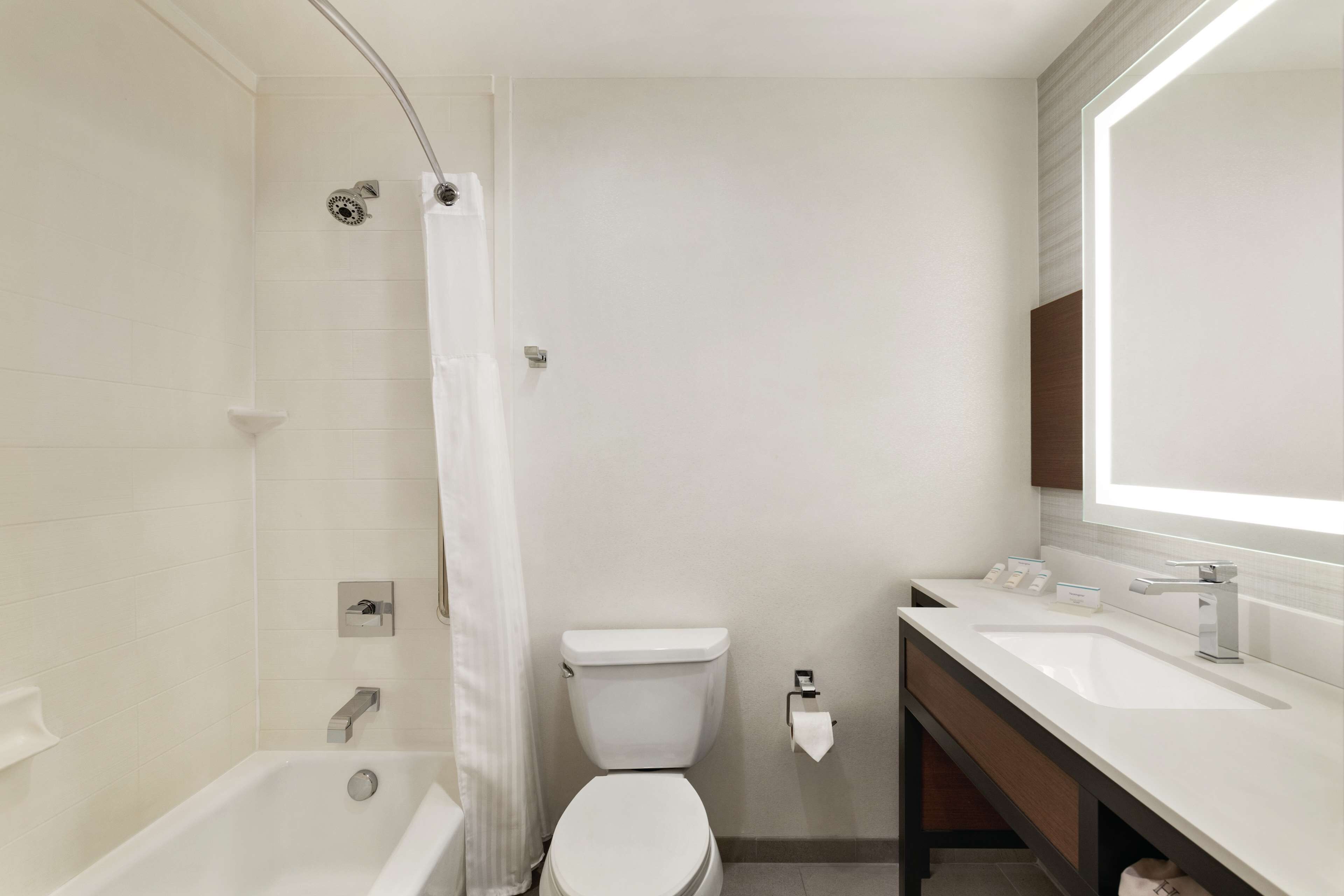 Une salle de bain moderne équipée d’une baignoire, de toilettes et d’un lavabo.