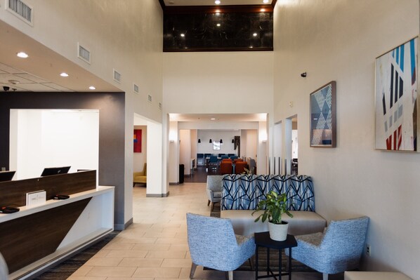 A reception area with a modern desk, seating, and artwork on the walls.