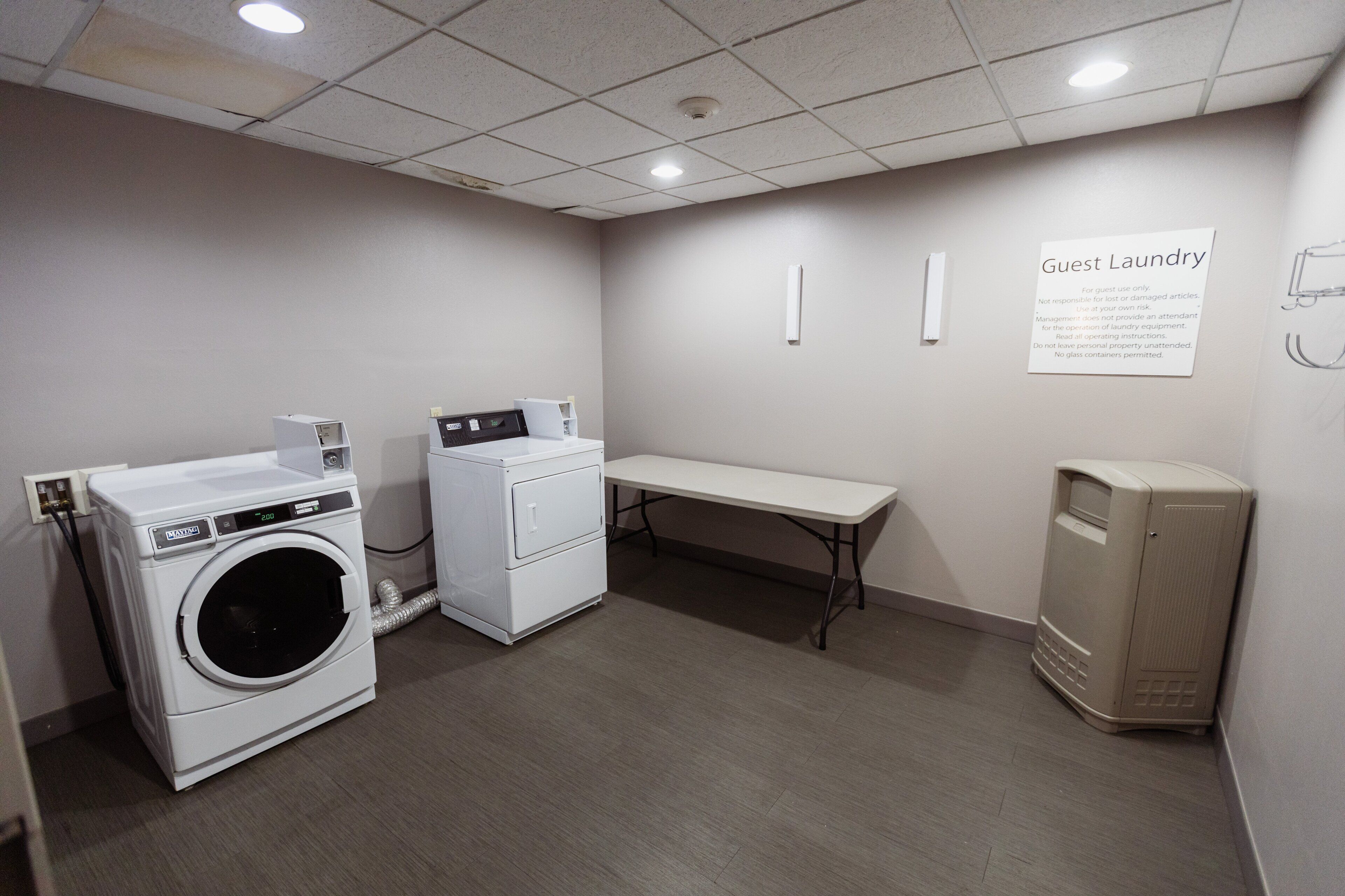 A laundry area with a washing machine, dryer, and a bench.