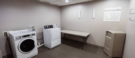 A laundry area with a washing machine, dryer, and a bench.