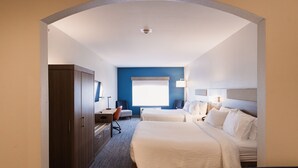 Une chambre d’hôtel avec deux lits, un bureau, une chaise, une armoire et une grande fenêtre.