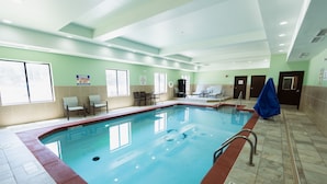 Une piscine intérieure avec un sol carrelé, un poste de surveillance pour sauveteur et un panneau indiquant qu’il n’y a pas de sauveteur de service.