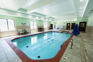 An indoor swimming pool with a tiled floor, a lifeguard chair, and a sign indicating no lifeguard on duty.