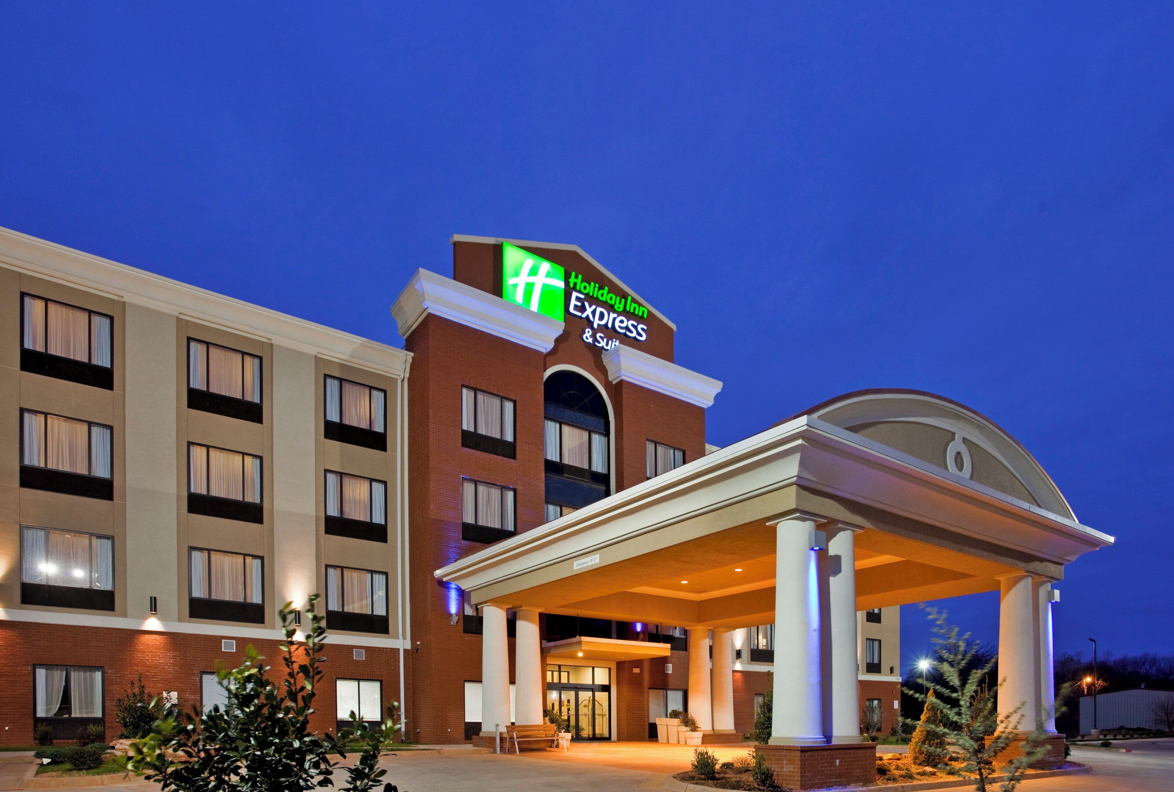 A Holiday Inn Express hotel with a prominent sign, a covered entrance, and a brick facade.