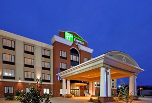 A Holiday Inn Express hotel with a prominent sign, a covered entrance, and a brick facade.