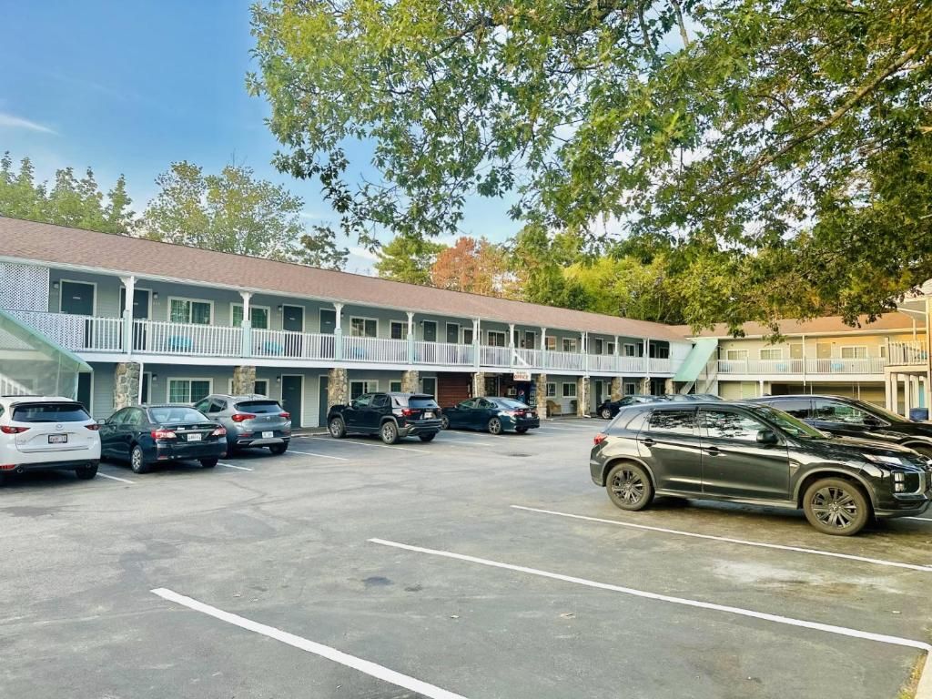 A motel with a parking lot and a covered walkway.