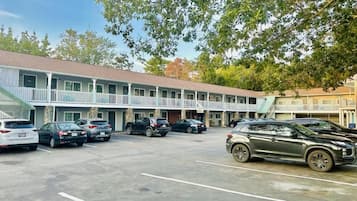 Um motel com estacionamento e galeria coberta.