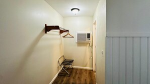 A narrow hallway with a wooden floor, a wall-mounted drying rack, and a wall-mounted air conditioning unit. - Hampton Motor Inn (Hampton)
