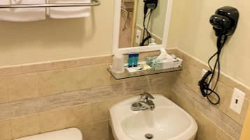 A bathroom with a sink, mirror, towel rack, and hairdryer.