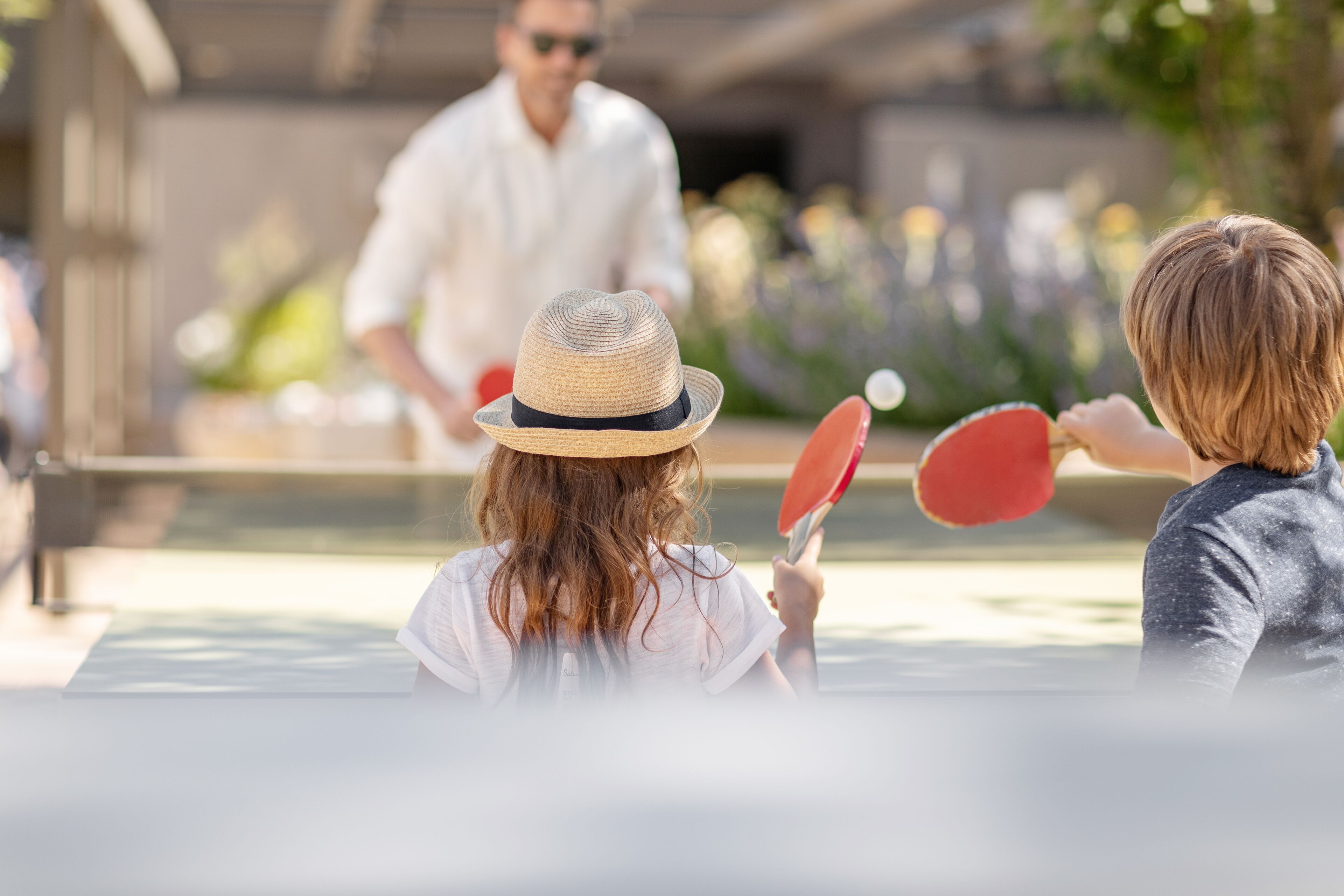 A person playing table tennis outdoors.