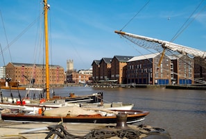 A harbor with boats docked, a crane, and buildings in the background. - City Centre Guest House - Gloucester Park (Gloucester)