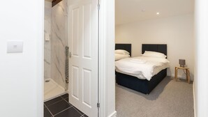 A bedroom with a bed, a bedside table, and a nightstand. - City Centre Guest House - Gloucester Park (Gloucester)