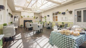 A spacious room with a high ceiling, a fireplace, and multiple tables with chairs. - The Highworth Hotel (Swindon)