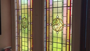 Two tall, narrow windows with colorful stained glass designs. - Dunallan House (Grantown-on-Spey)