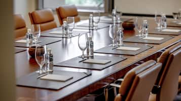 A conference room with a long table, multiple chairs, water bottles, and glasses.