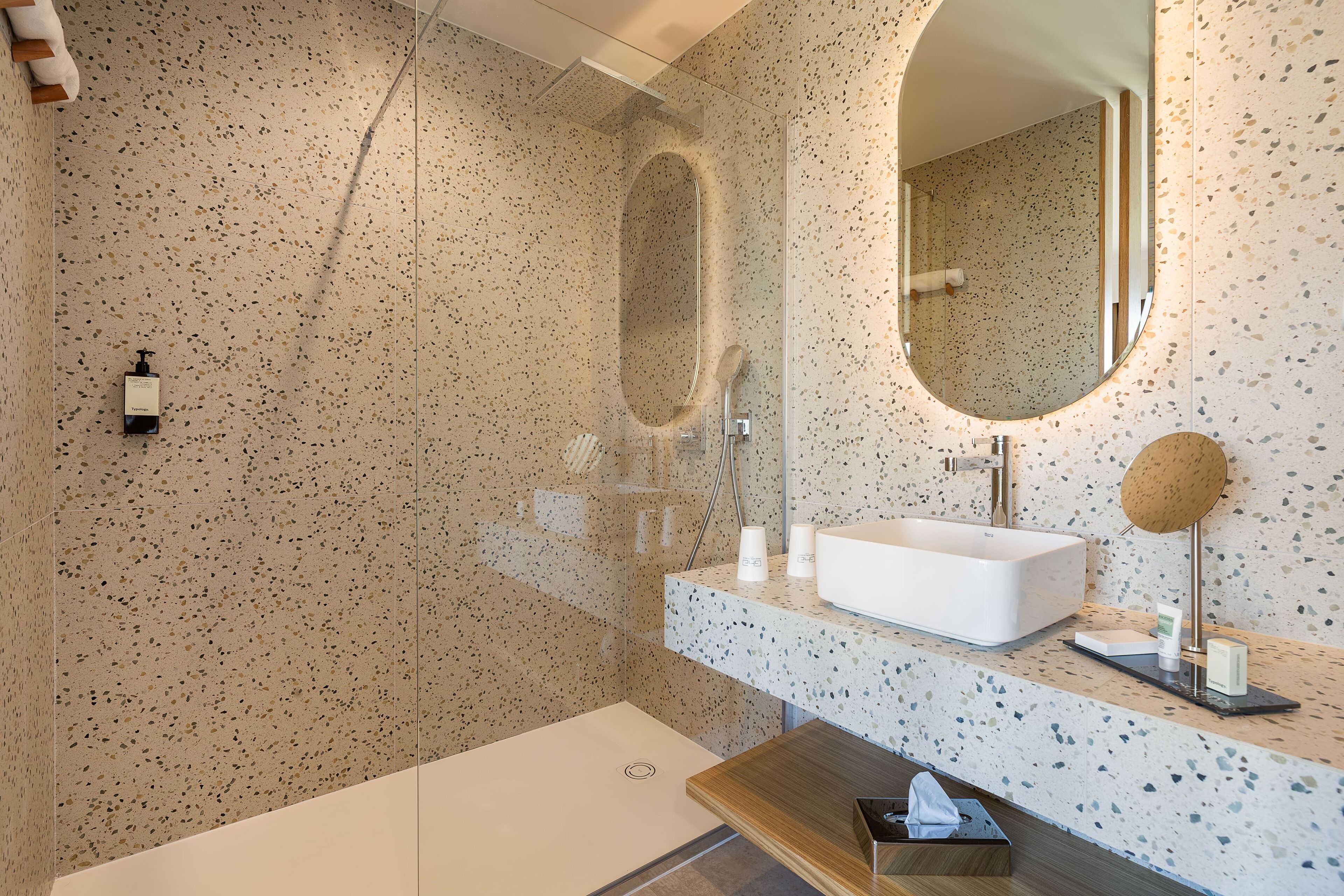 A modern bathroom with a freestanding bathtub, a large mirror, and a sink with a countertop.