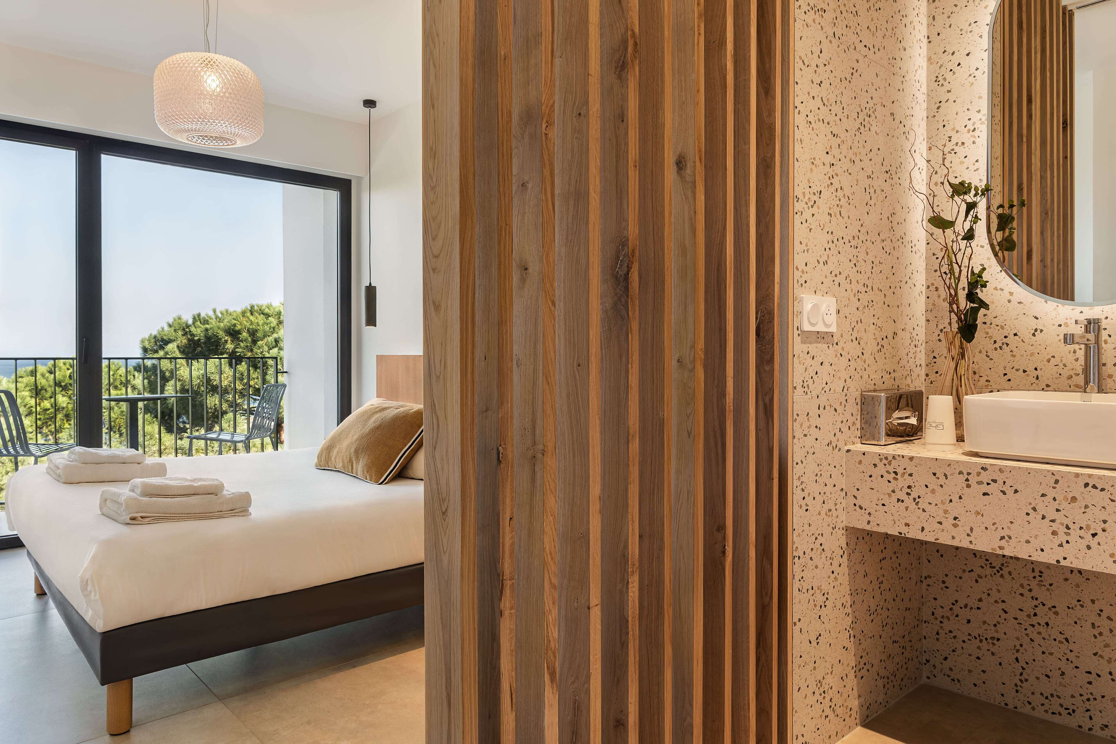 Ein Schlafzimmer mit einem Bett, einem großen Fenster und einem Balkon.