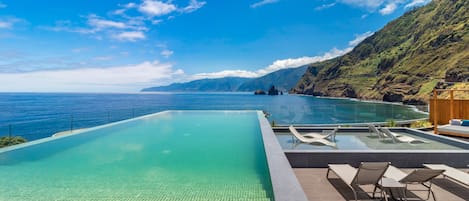 Una piscina cubierta, una piscina al aire libre, sombrillas, tumbonas