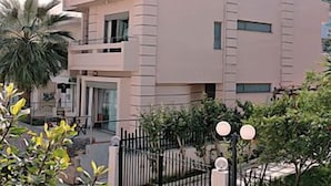 A modern multi-story building with a flat roof, large windows, and a balcony. - Maria Apartments (Malevizi)