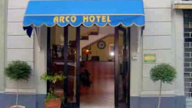 The exterior of Arco Hotel with a blue awning and potted plants at the entrance. - Arco Hotel (Milan)