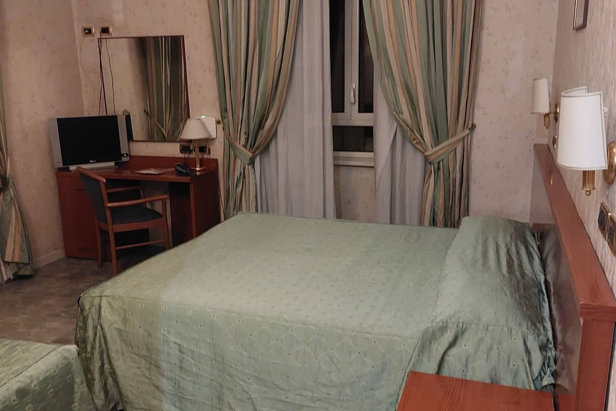Camera tripla | Una cassaforte in camera, una scrivania, tende oscuranti, lenzuola