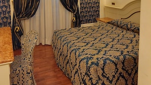 A hotel room with a large bed, a chair, a desk, and a mirror. - Hotel Dina (Rome)