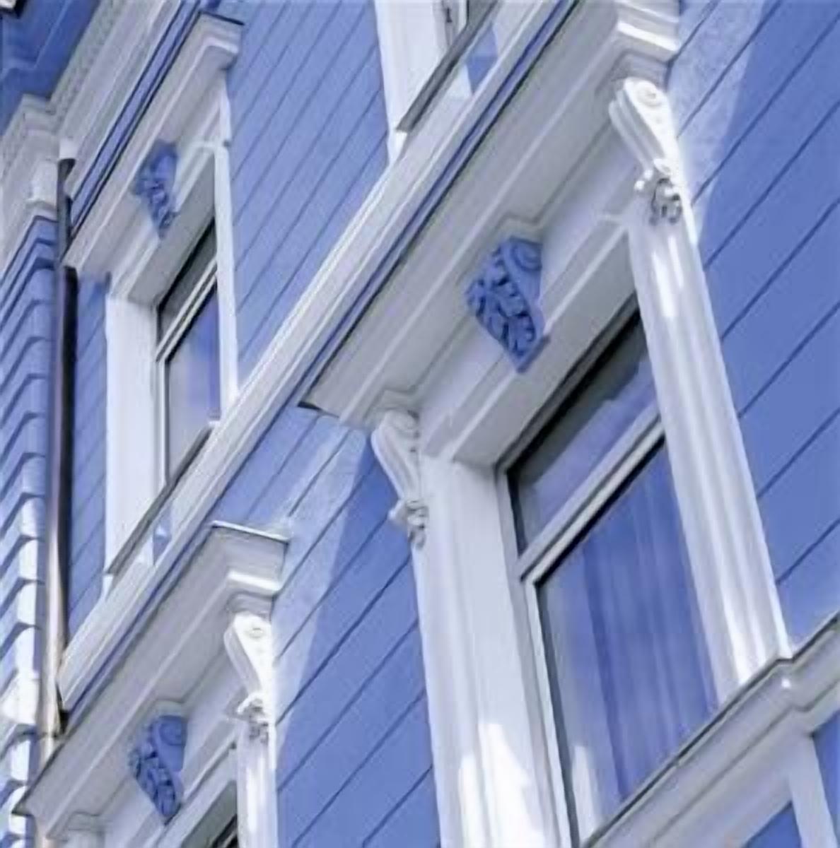 A building with blue siding and white trim around windows and doors.
