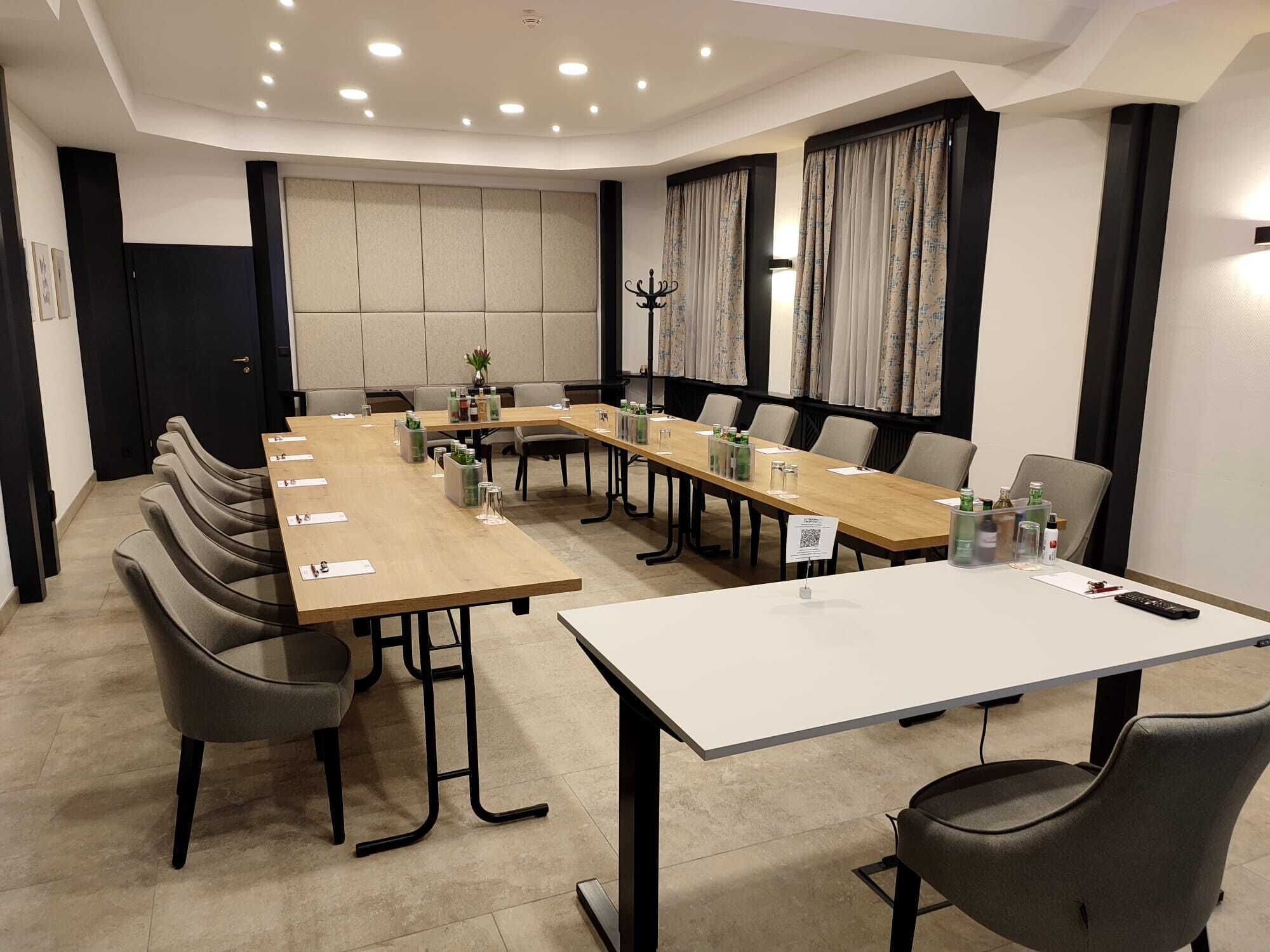 A conference room with a long table, chairs, and a whiteboard.