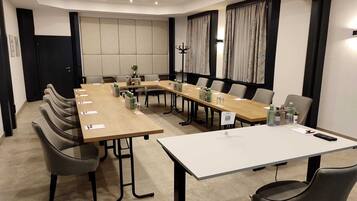 A conference room with a long table, chairs, and a whiteboard.