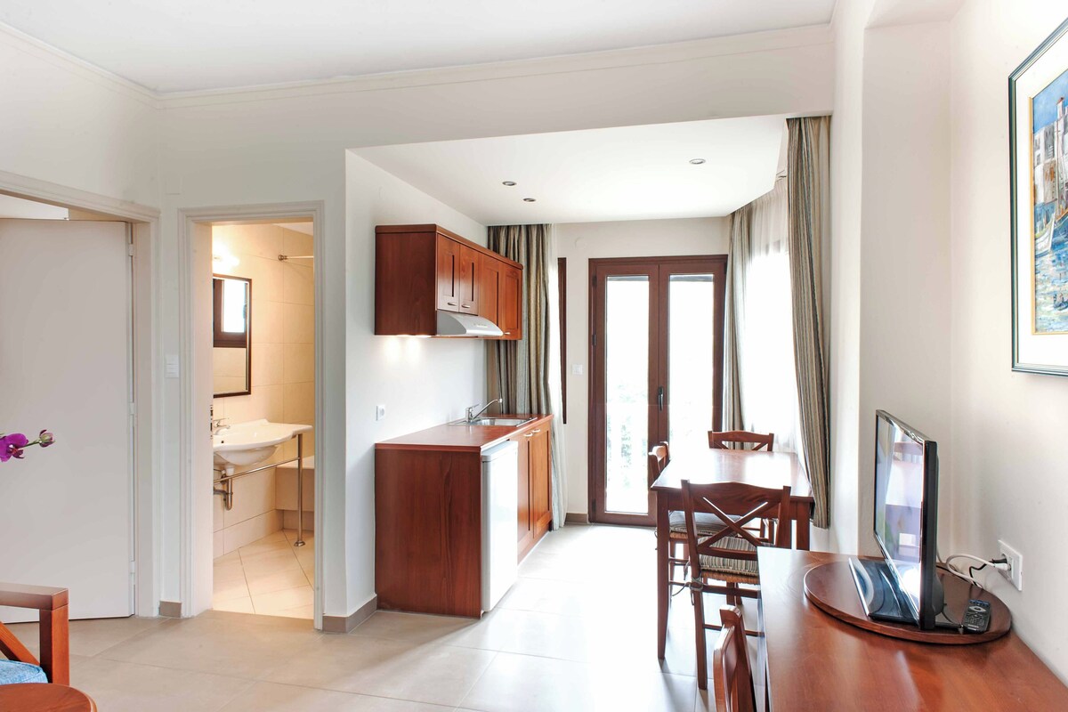 A compact living space with a kitchenette, a dining area, and a bathroom.